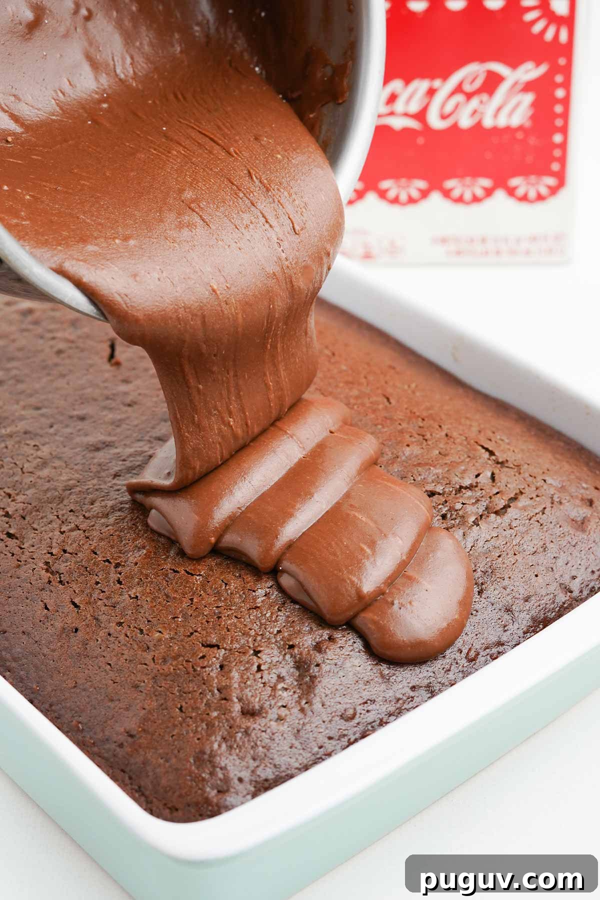 Copycat Cracker Barrel Coca-Cola Cake Recipe You’ll Love 9 Pouring the icing over the top of the coca cola cake.