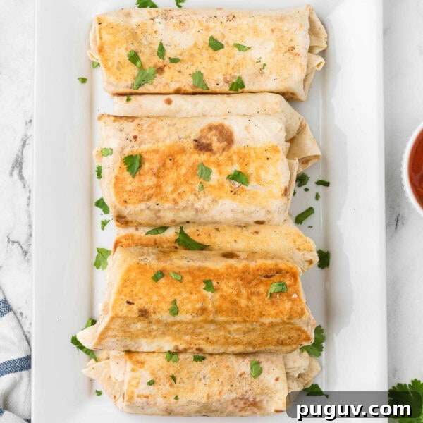 Easy breakfast burrito on a white plate.