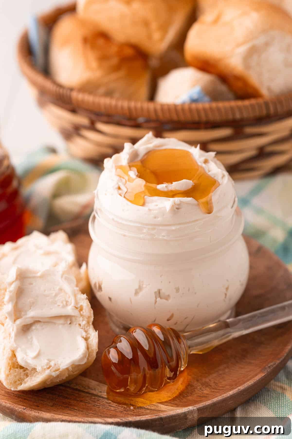 Light and Fluffy Honey Whipped Butter for Toast and Baking 2 A jar filled with whipped honey butter on a wooden plate.