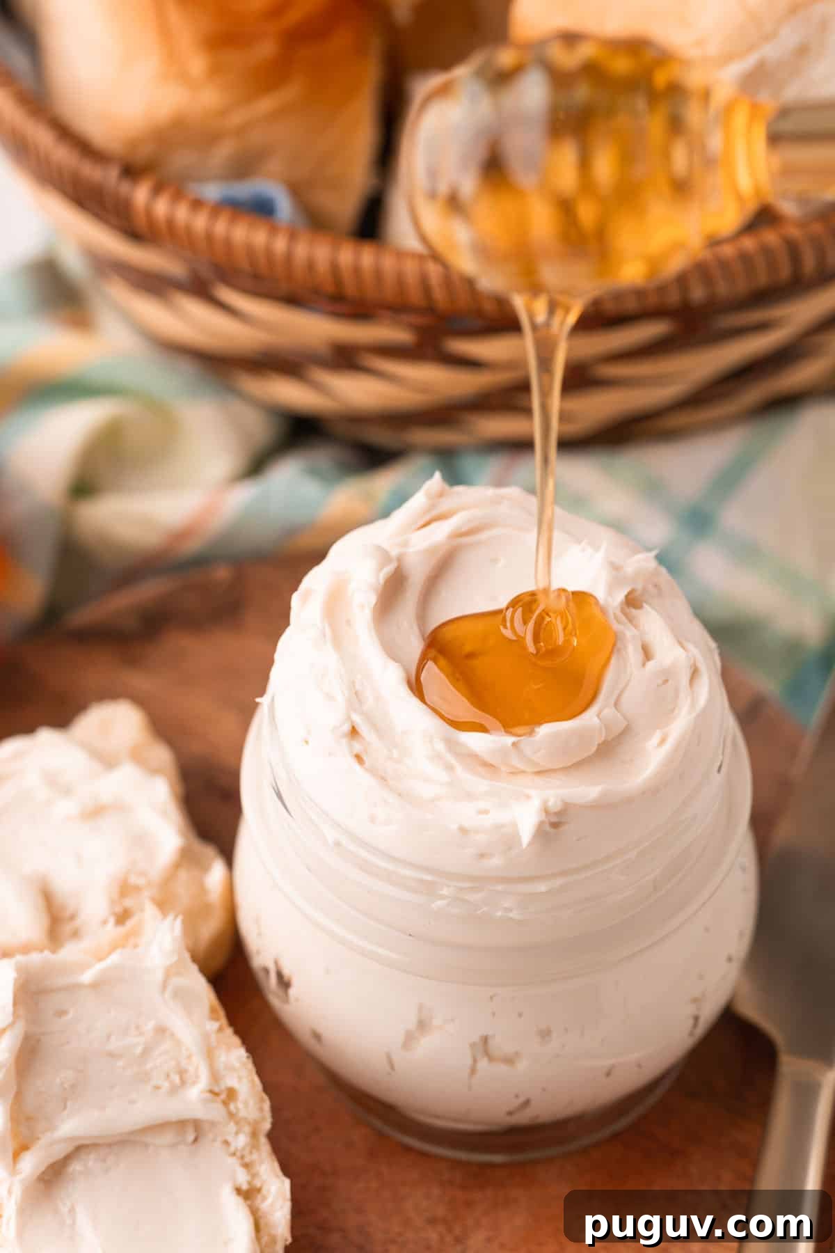 Light and Fluffy Honey Whipped Butter for Toast and Baking 3 Honey being drizzled on top of a jar of whipped honey butter.