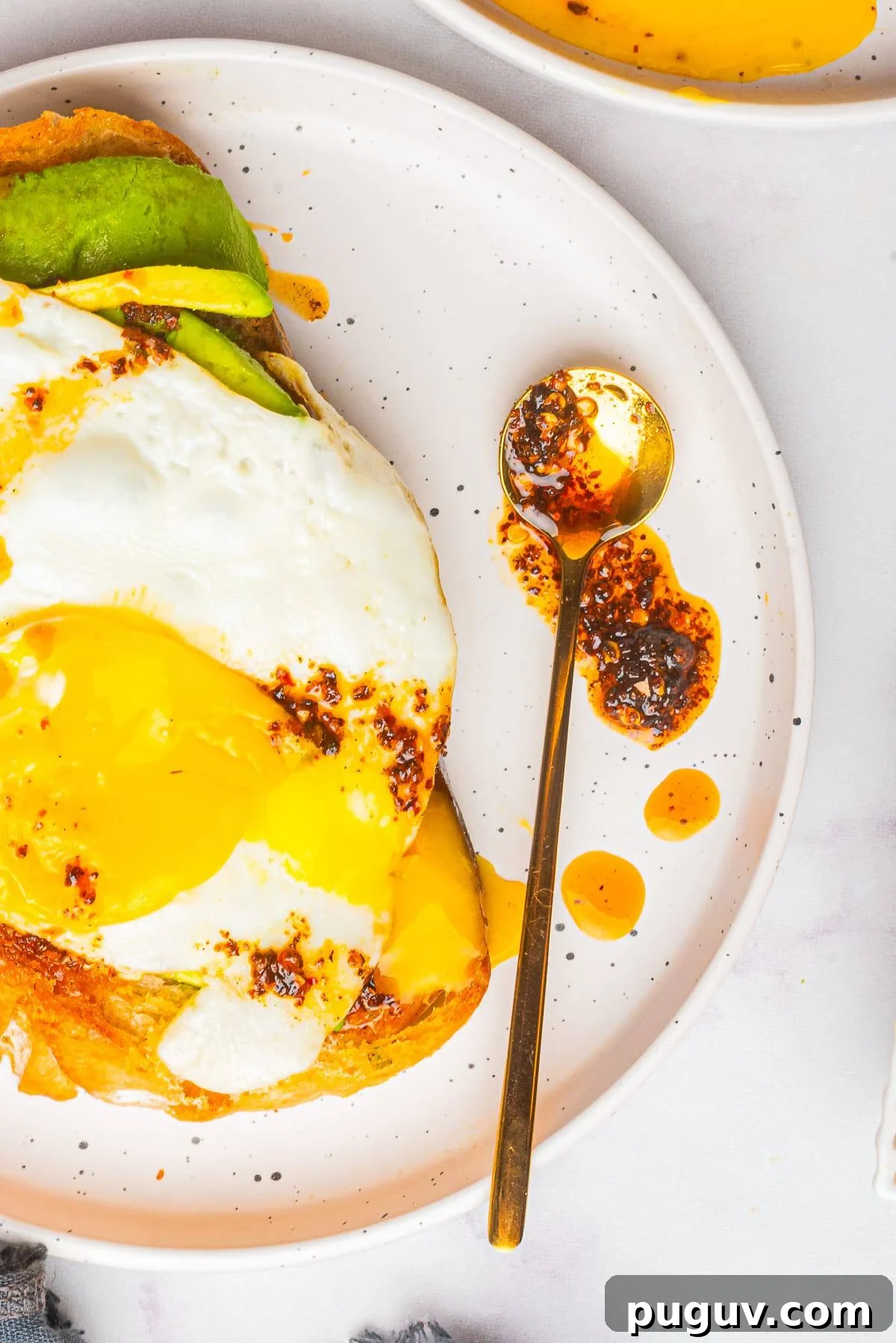 Homemade Chili Oil Recipe: Step-by-Step Guide for Authentic Flavor 6 overhead image of Chili Oil on a spoon on a plate with avocado toast