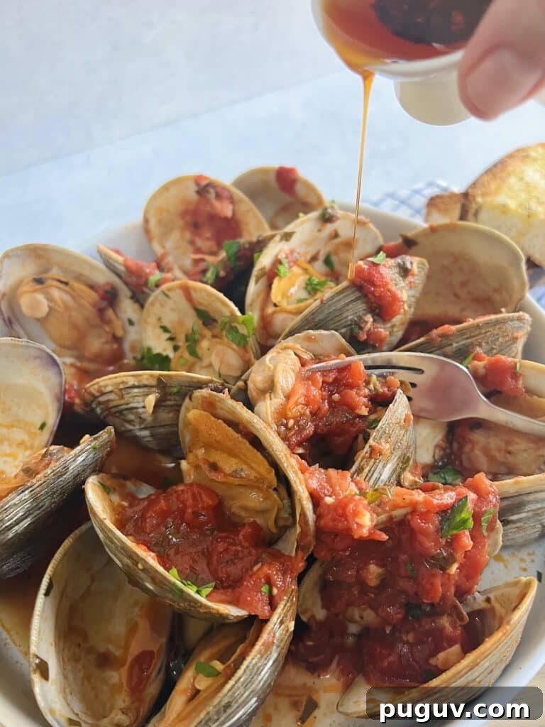 Clams Posillipo in Spicy Tomato Sauce (Zuppa di Vongole) 12 Pouring spicy pepper oil over clams posillipo.