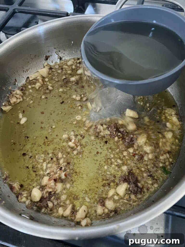 Clams Posillipo in Spicy Tomato Sauce (Zuppa di Vongole) 9 White wine being added to garlic parsley mixture for clams in red sauce.
