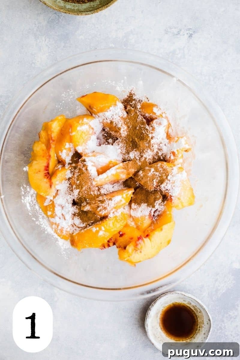 Gluten-Free Peach Oat Crumble Recipe for Summer Desserts 4 Peaches, cinnamon, arrowroot, and salt in a glass mixing bowl.