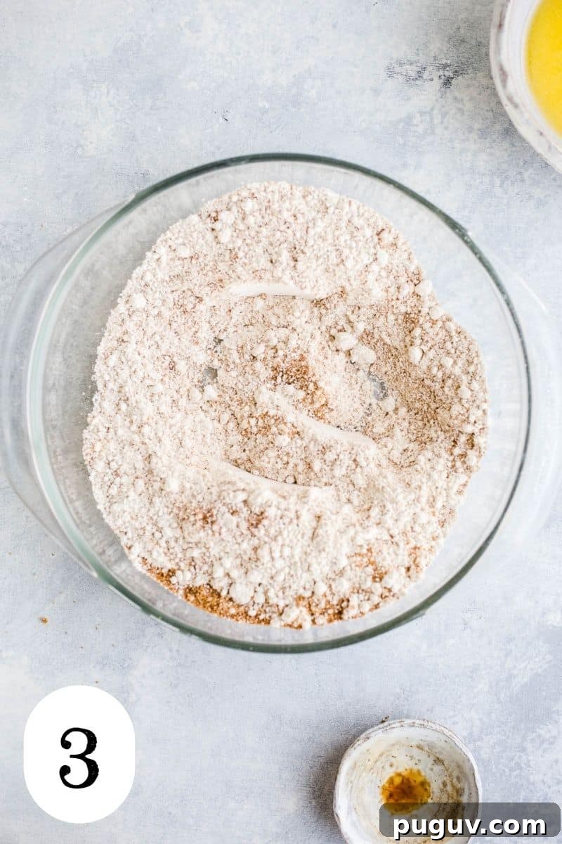 Gluten-Free Peach Oat Crumble Recipe for Summer Desserts 6 Oat flour, coconut sugar, and salt mixed together in a glass mixing bowl.