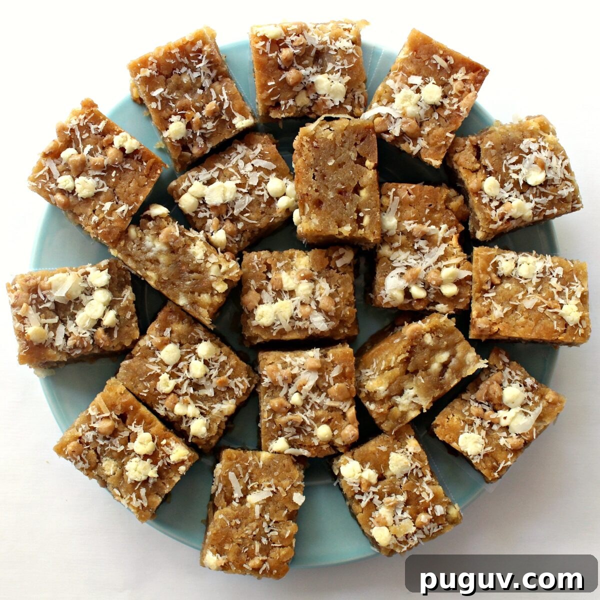 Coconut Milk Blondies Recipe: Chewy, Dairy-Free Dessert 4 Coconut Blondies on a blue serving plate.