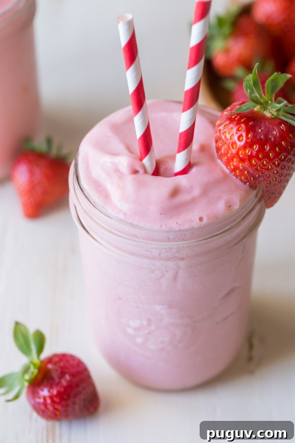 Pineapple Strawberry Cream Slush Recipe — Refreshing Tropical Drink 3 Dole Pineapple Strawberry Cream Slush in a glass jar, with two straws and a strawberry on the rim of the jar.