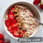 Overnight oats with strawberries, topped with granola and fresh berries.