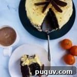 A chocolate orange cake with a slice cut out and placed on a plate.
