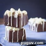 Side view of two pieces of fudge stacked on top of each other on a blue napkin.
