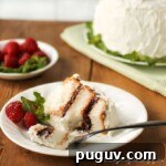 Side view of a slice of Mom's refrigerator cake on a white plate with the whole cake in the background.