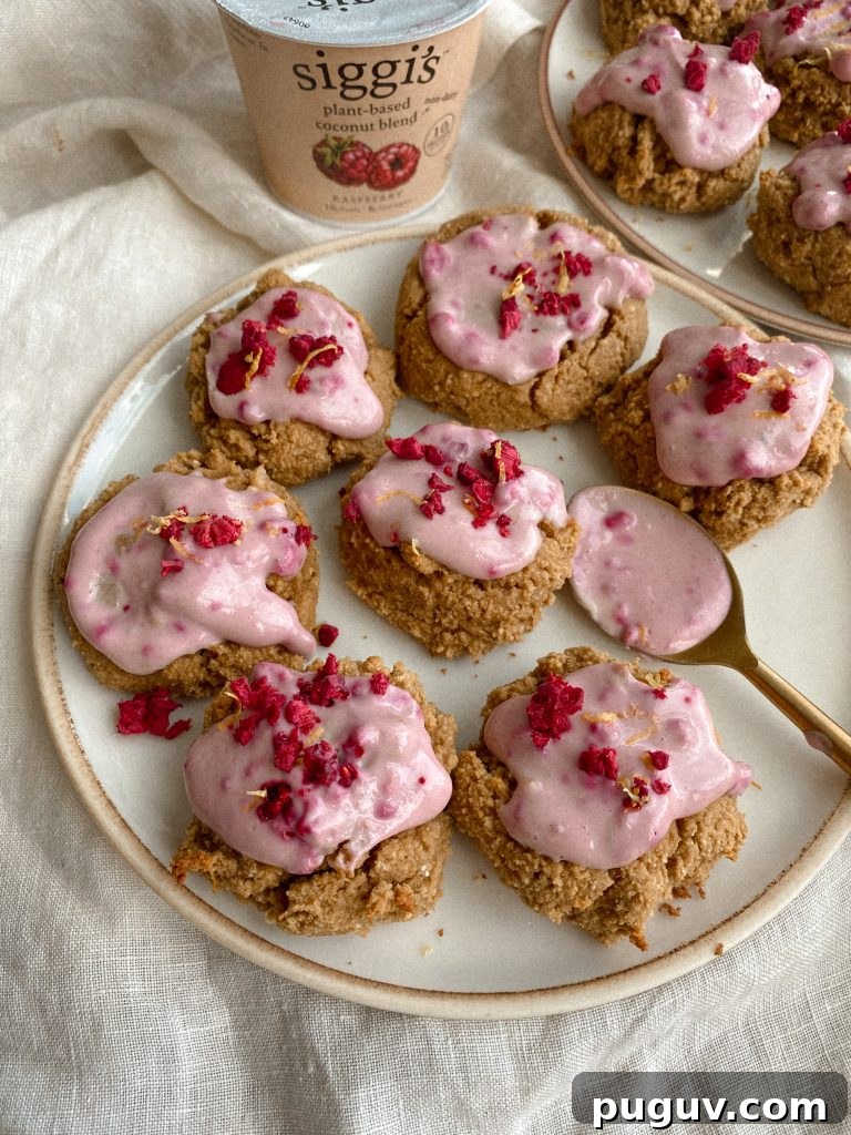 cookies with raspberry yogurt frosting on plates with cup of yogurt