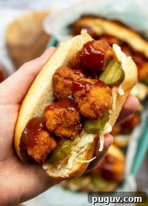Popcorn Chicken Sandwich overhead shot of holding sandwich close to camera with more blurred in background