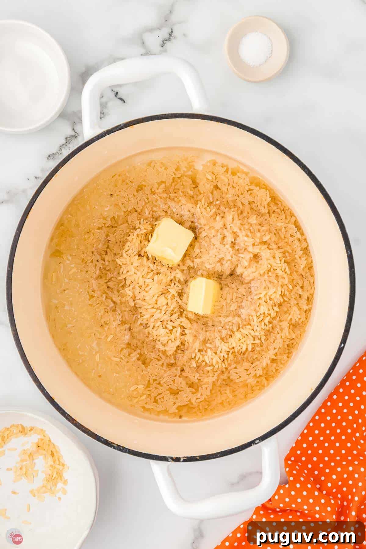 pot with uncooked rice, butter, and a little water in it