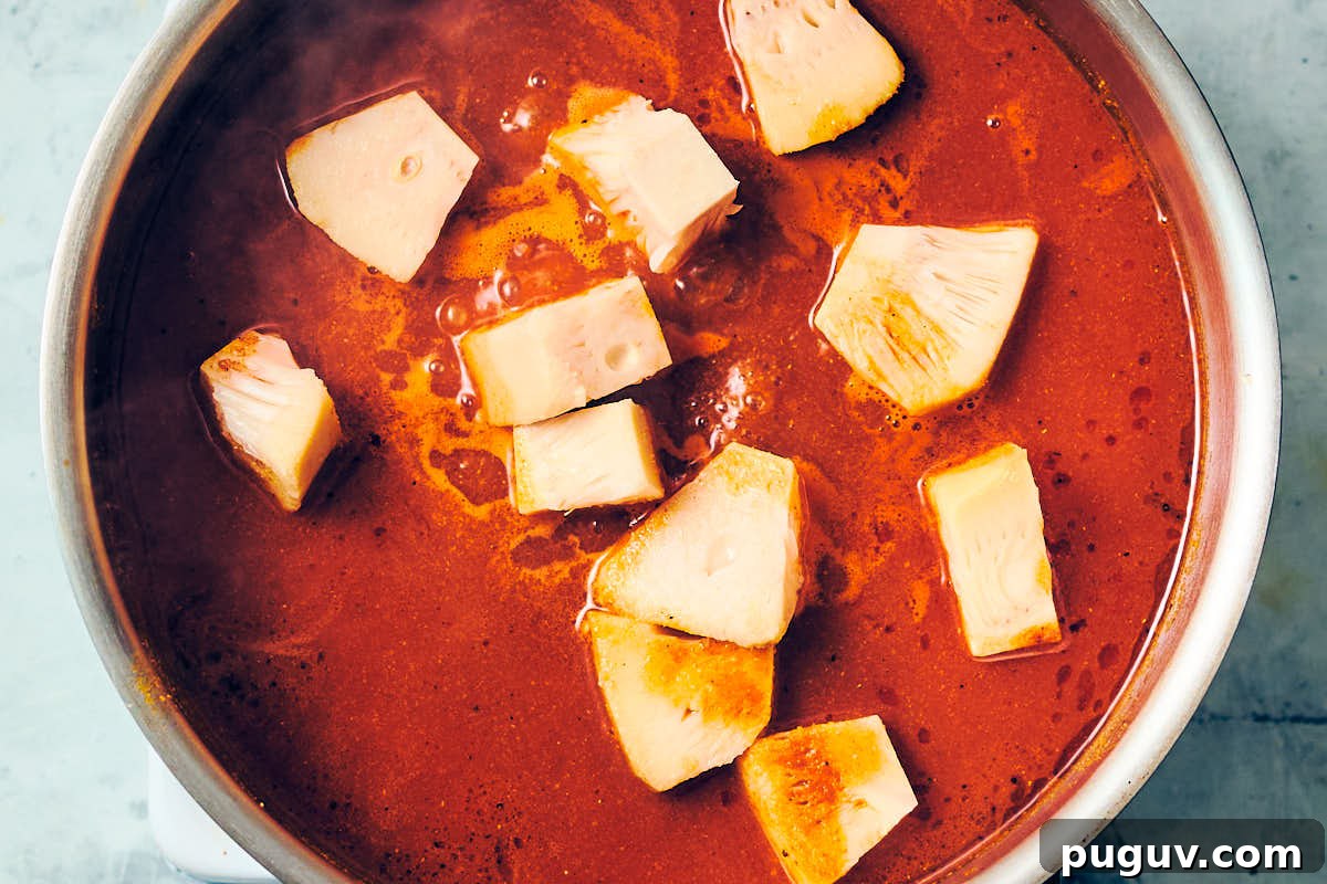 Jackfruit simmering in skillet with spices for vegan shawarma.
