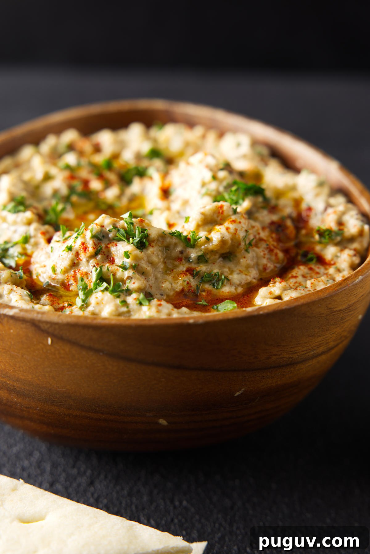 Smoked Baba Ganoush Recipe: Creamy Charred Eggplant Dip 6 Smoked Baba Ganoush in a wooden bowl topped with chopped parsley and olive oil.