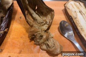 Smoked Baba Ganoush Recipe: Creamy Charred Eggplant Dip 10 Scraping flesh from roasted eggplant.