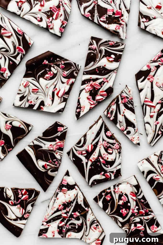 peppermint bark broken up on a marble tray with crushed candy canes on top