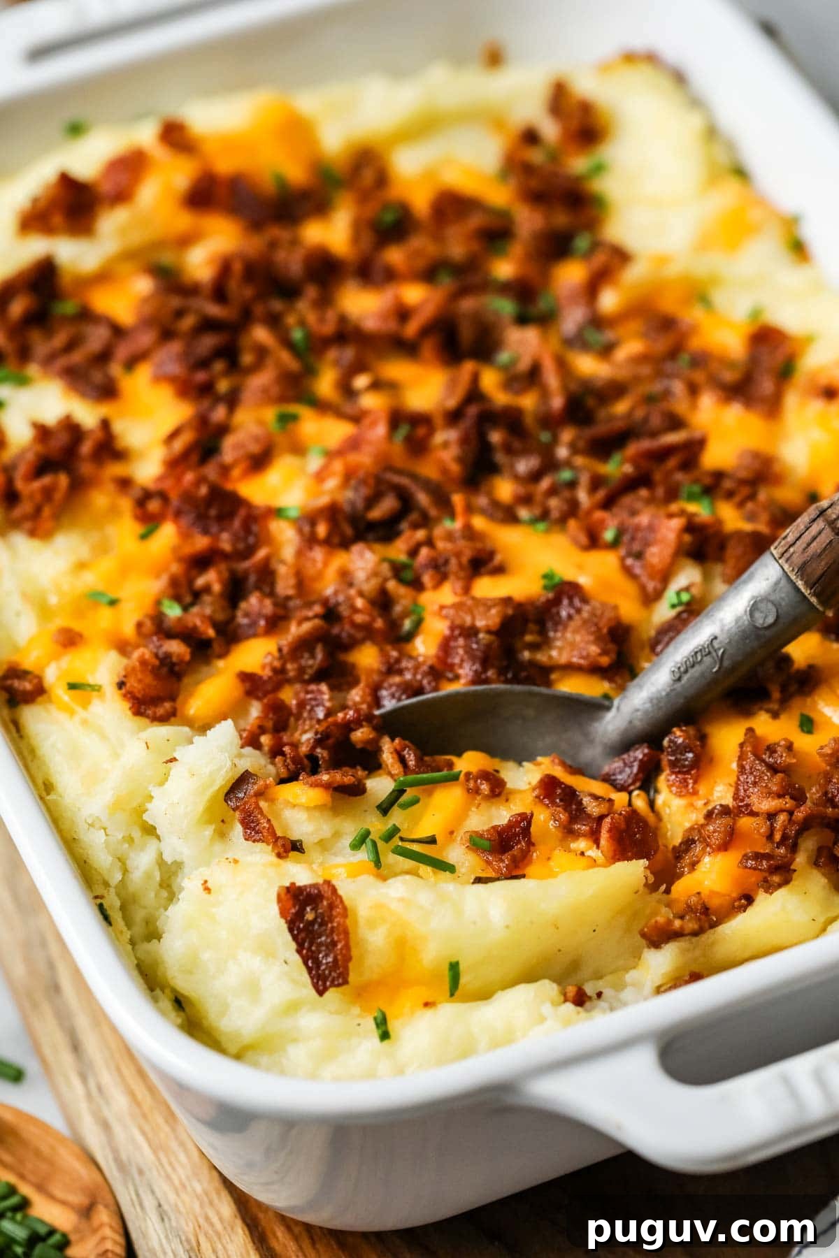 Cheesy Bacon Loaded Mashed Potato Casserole Recipe 7 Spoon scooping a serving of mashed potato casserole out of a dish.