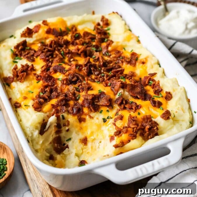 Cheesy Bacon Loaded Mashed Potato Casserole Recipe 8 Dish of loaded mashed potato casserole with one serving missing.