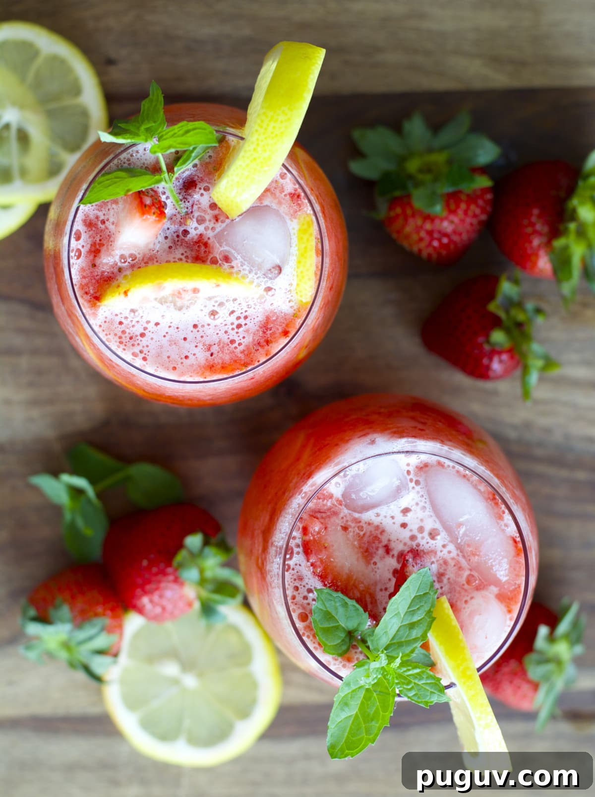 overhead view of two glasses of blended lemonade with strawberries