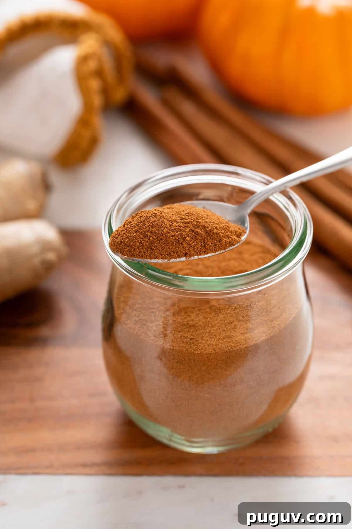 How to Make Pumpkin Pie Spice at Home for Cozy Fall Baking 6 Jar of pumpkin pie spice with a spoonful of the spice resting on the lip.