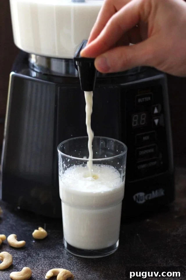 Healthy Vegan Pumpkin Spice Latte - the NutraMilk Dispensing Nut Milk in a Glass Closeup with the Glass Half-Filled