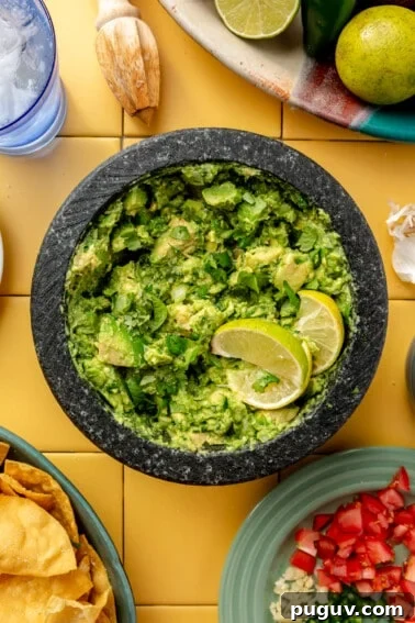 Loaded Texas Nachos Recipe: How to Make Classic Tex-Mex Nachos 12 Molcajete with guacamole topped with lime wedges.