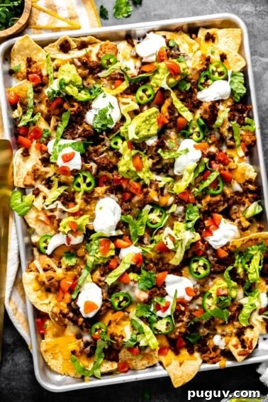 Loaded Texas Nachos Recipe: How to Make Classic Tex-Mex Nachos 16 Sheet pan nachos with ground beef topped with sour cream and guacamole.