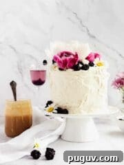 decorated cake with peonies and blackberries