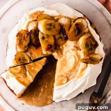 Decadent Banoffee Cake Recipe with Caramelized Banana Topping 16 cutting a slice of cake with bananas and caramel sauce