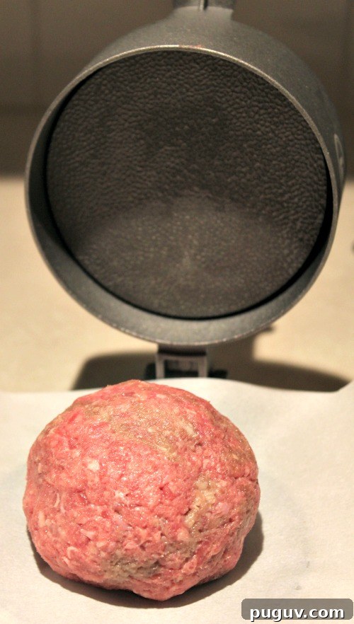 Grill a Perfect Burger: Tips for Juicy, Evenly Cooked Patties 4 Ball of ground beef for a burger on parchment paper and burger press