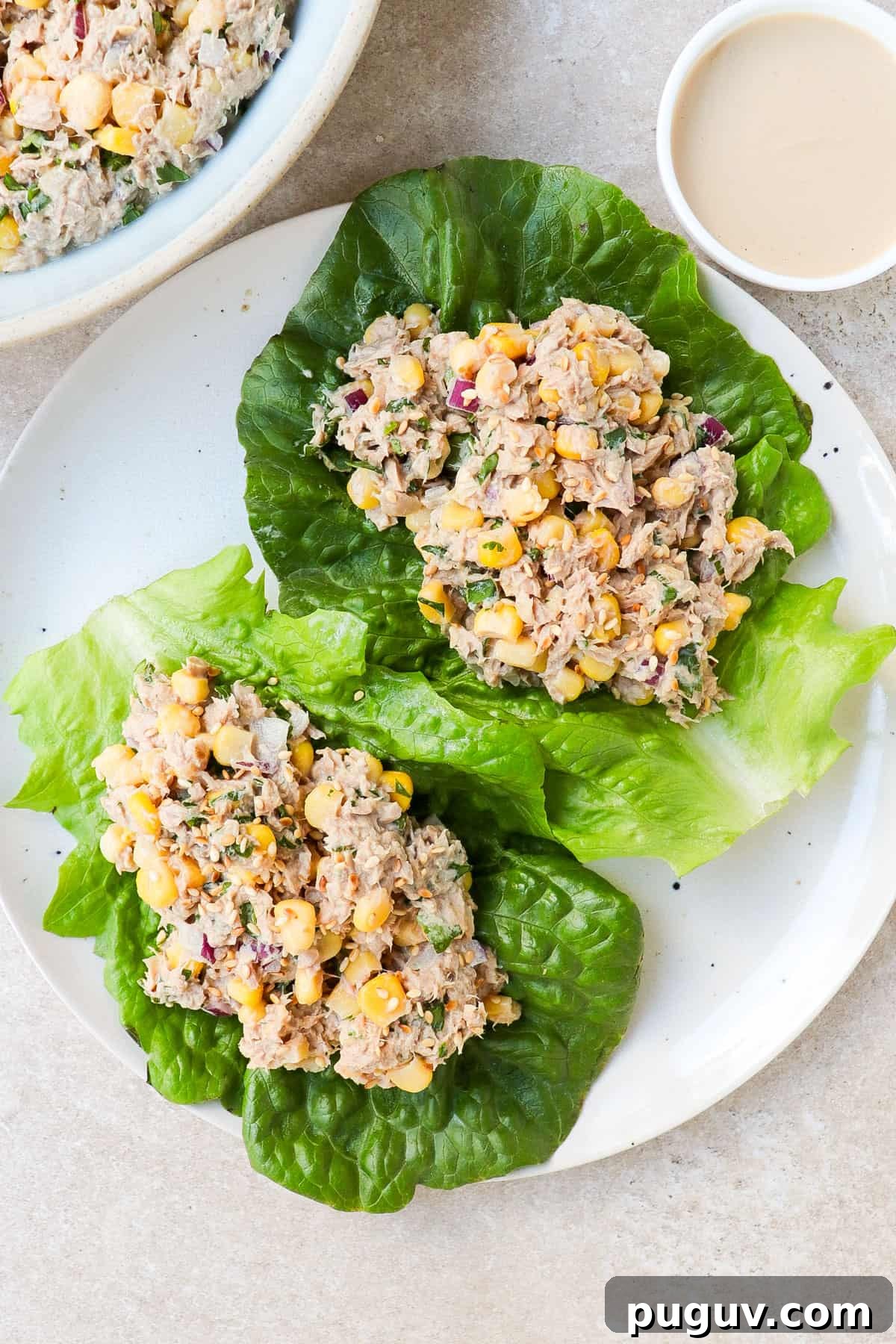 Tuna and corn salad on two lettuce leaves.
