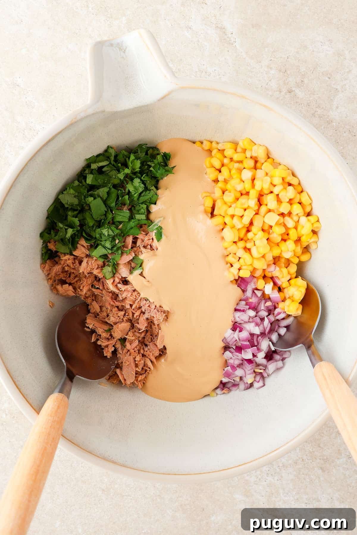 Tuna salad ingredients in a mixing bowl.