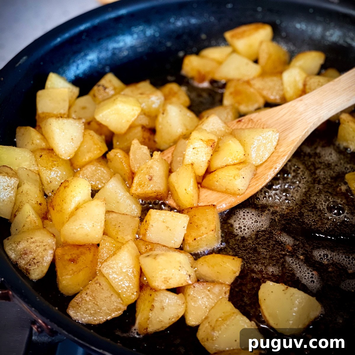 Truffled Fried Potatoes with Creamy Split Pea Soup 6 Someone using a wood spoon to stir potatoes in a hot skillet while they fry in butter and oil.