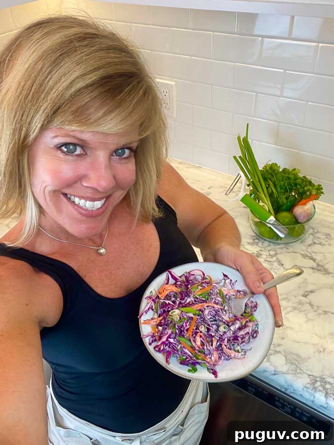 Purple Cilantro Lime Slaw Recipe for Fresh, Tangy Side Dish 3 JENNIFER holding a white plate of purple lime slaw