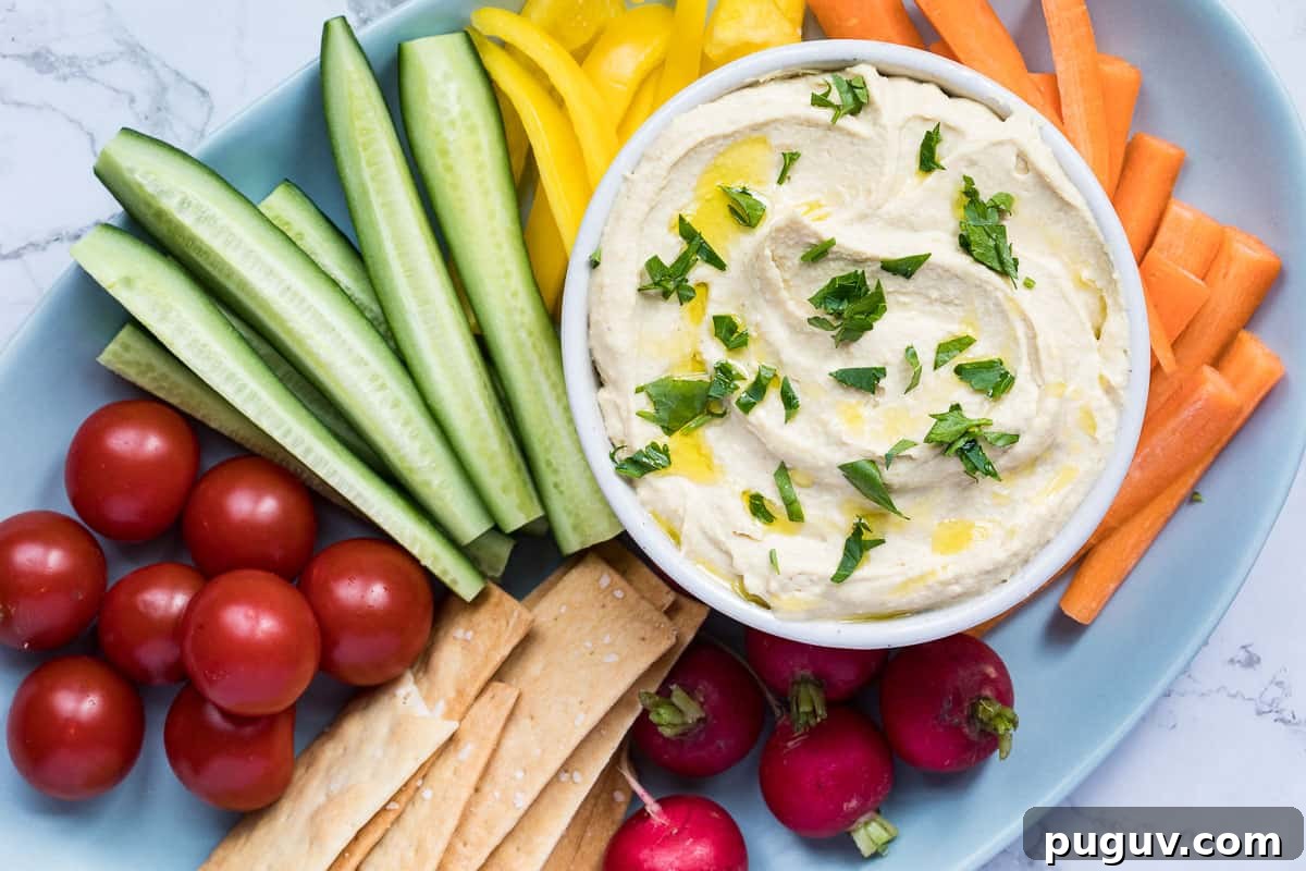 Creamy Roasted Garlic Hummus Recipe for Smooth, Flavorful Dip 7 roasted garlic hummus on platter with veggies and crackers.