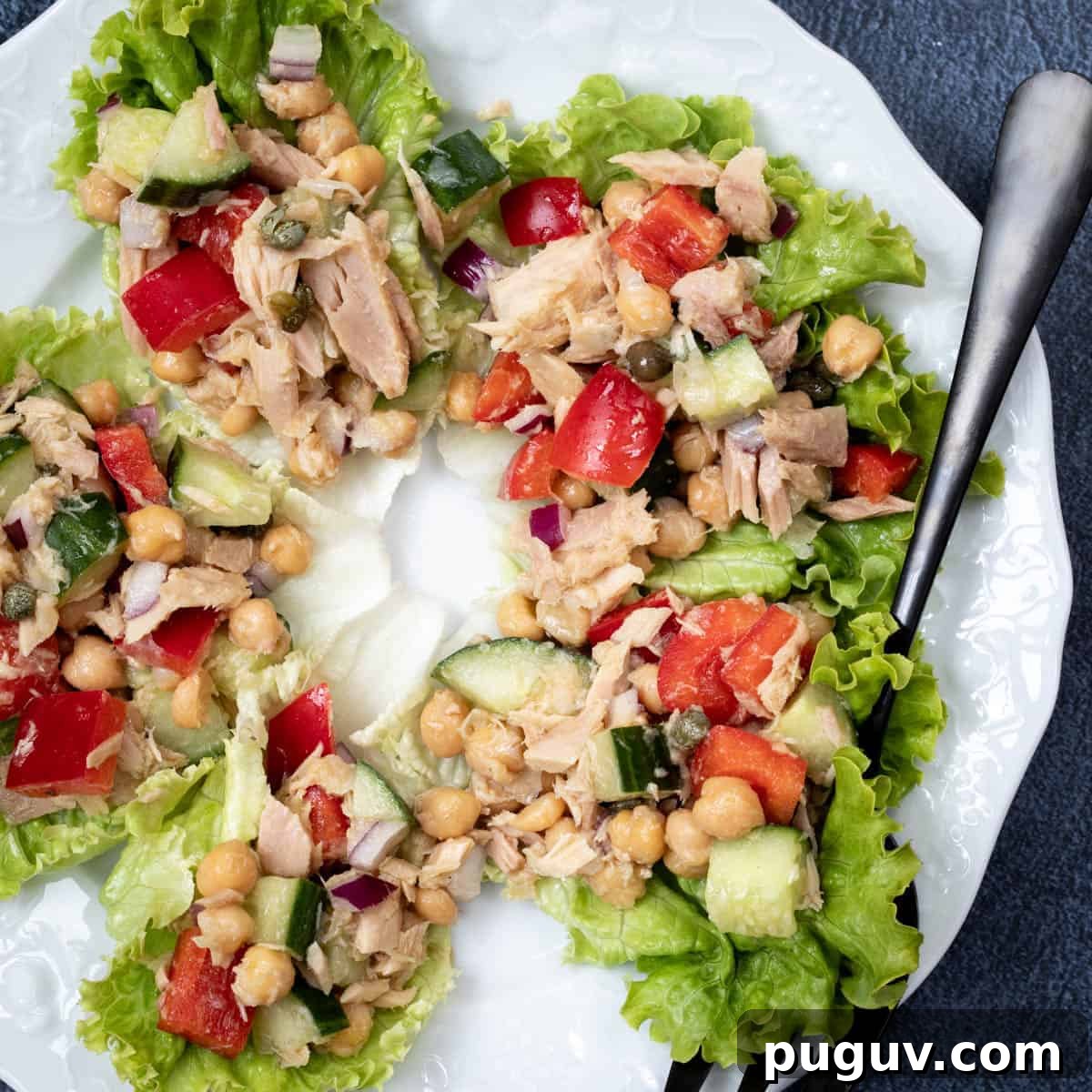 overhead shot of chickpea tuna salad in lettuce cups on white plate with fork