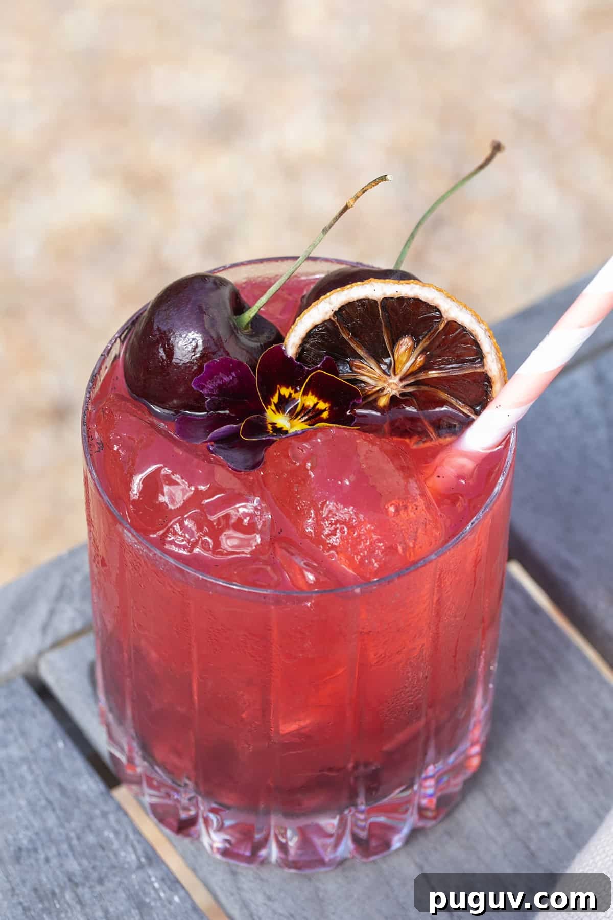 Easy summer cocktail recipe with cherries, lemon, gin and soda water.