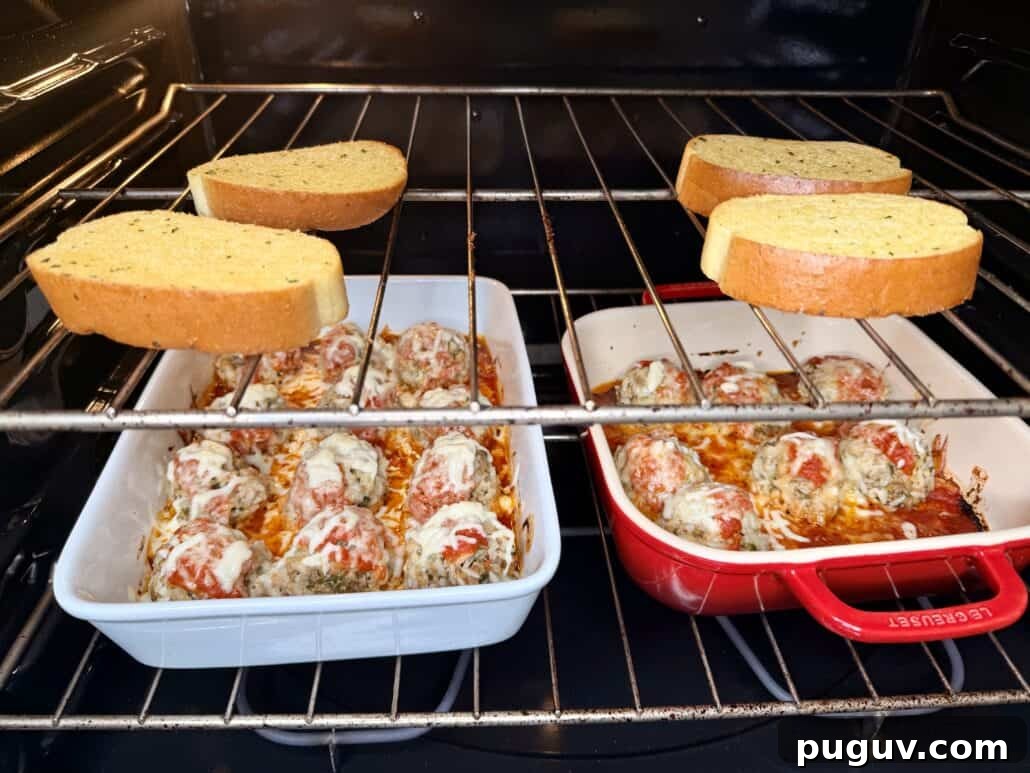 Italian-Style Baked Rice and Meatball Casserole 9 Two dishes of cheesy baked meatballs in tomato sauce sit on the middle oven rack, while four slices of bread toast on the top oven rack.