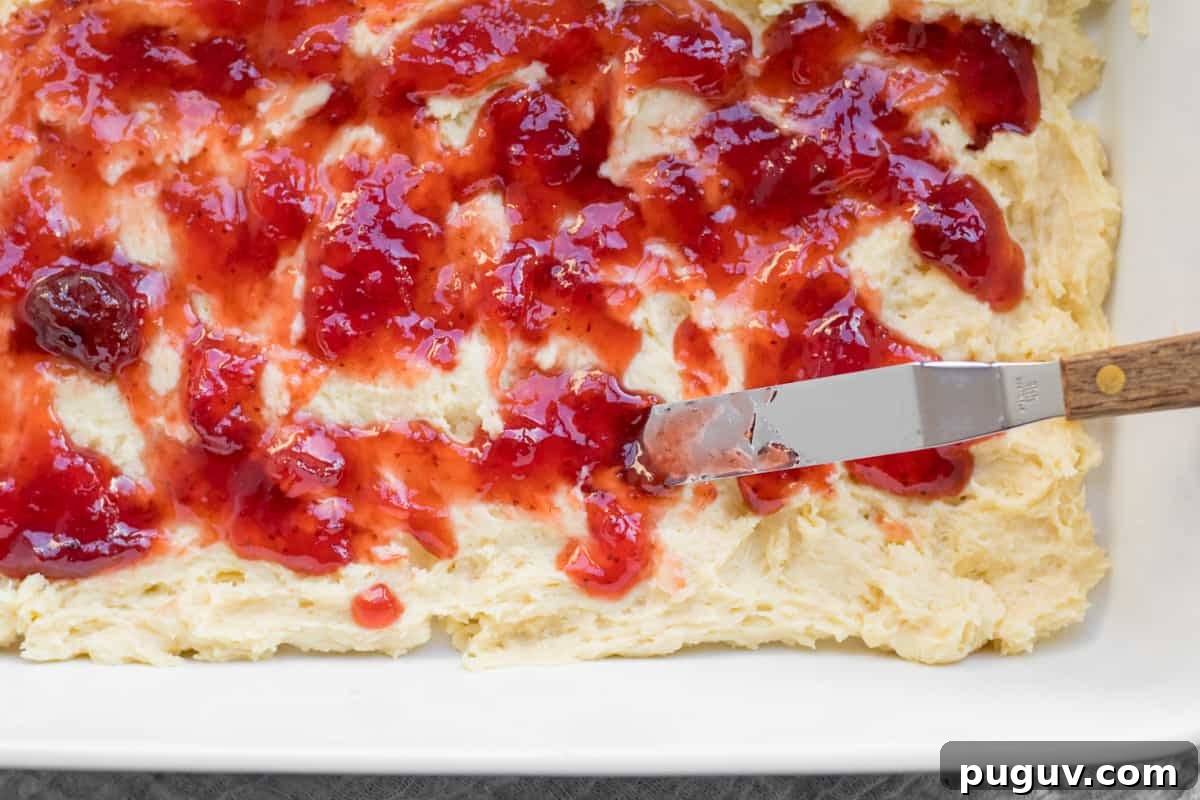 jam being spread over batter of coffee cake