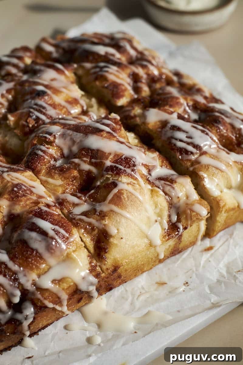 Sourdough Discard Cinnamon Roll Focaccia Recipe 13 A side view of the frosting dripping on the Sourdough Discard Cinnamon Roll Focaccia.