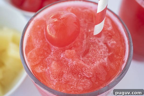 Cherry slush with straw and a cherry