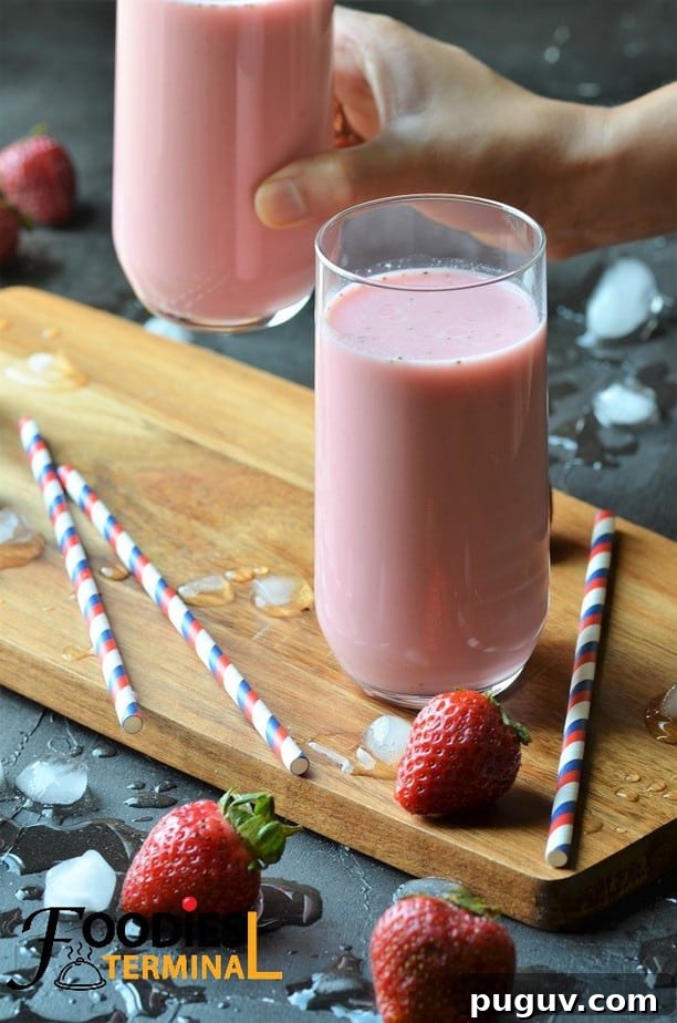 Refreshing Homemade Strawberry Lassi Recipe: Creamy Yogurt Drink 3 Creamy strawberry lassi recipe in a glass on a wood board