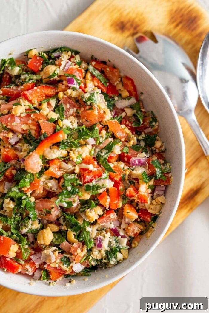 Chickpea Tabbouleh Salad with Fresh Herbs and Lemon Dressing 6 A bowl full of tabouleh salad on a cutting board.