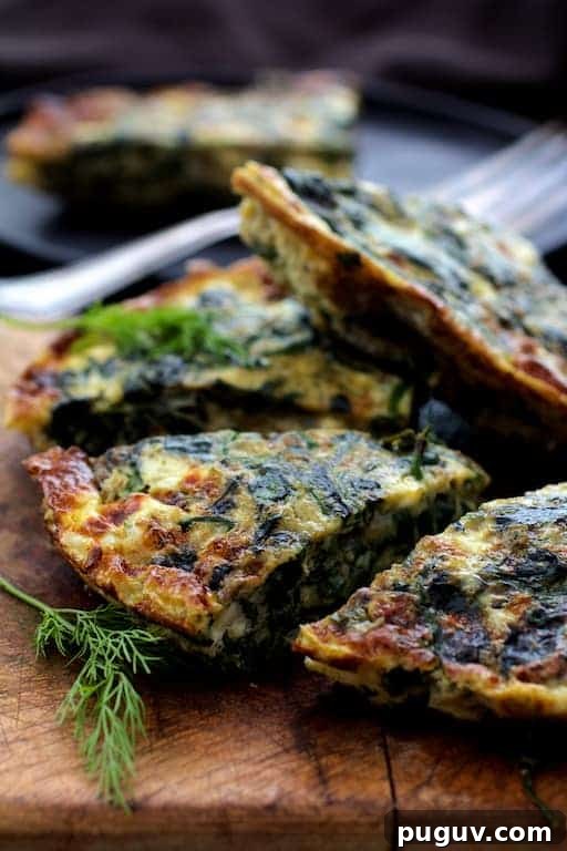 Spinach, Leek & Feta Frittata Recipe for Brunch or Dinner 7 Close-up photo of frittata wedges on wood cutting board garnished with fresh dill.