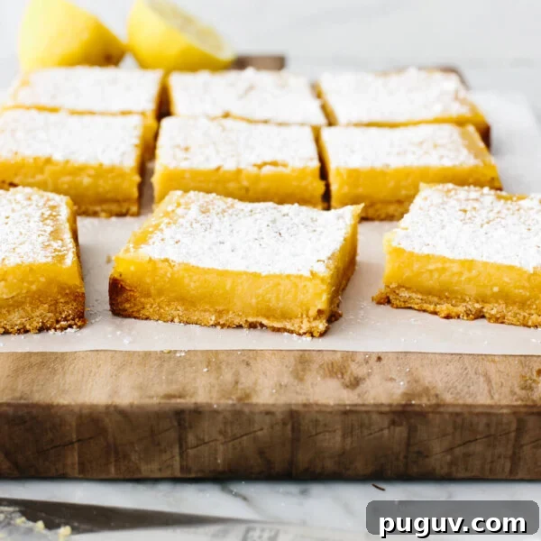 Sliced lemon bars on a wooden board.
