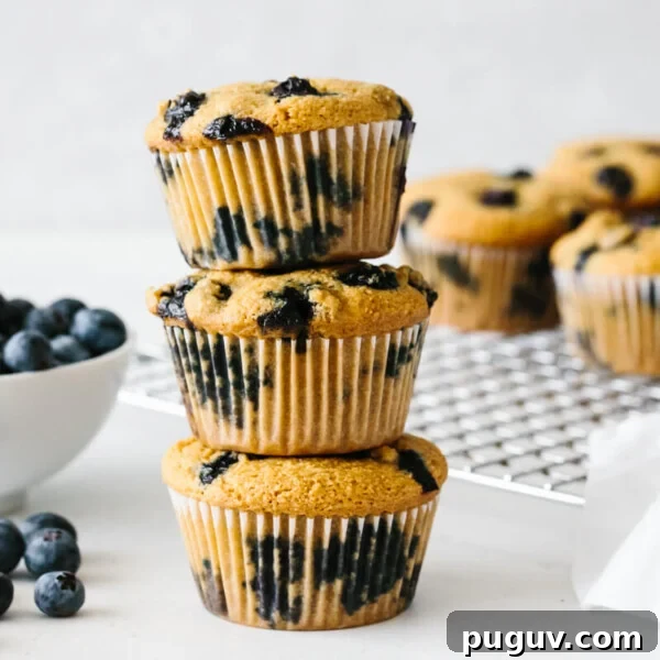 Paleo blueberry muffins stacked on top of each other.