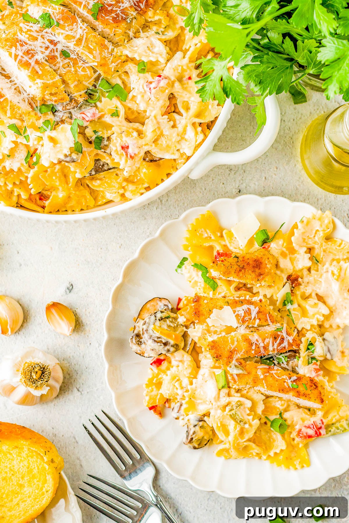 A serving dish of Cajun chicken pasta next to a plate of the pasta.