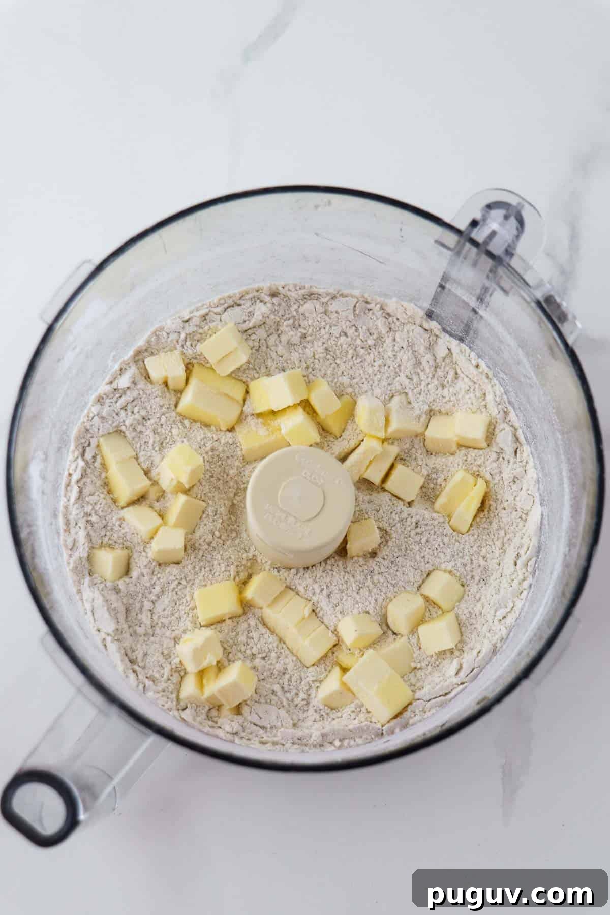 Brown Sugar Cardamom Scones Recipe for Tender, Buttery Pastries 4 Flour and cubed butter in the work bowl of a food processor.